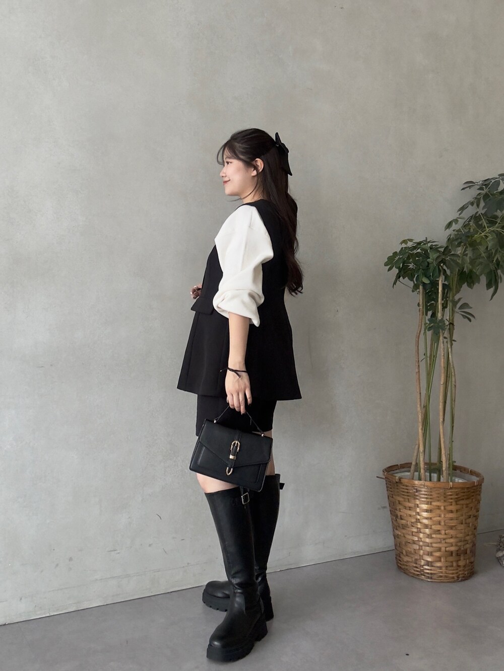 ホワイト系のニット/セーター、ブラック系のその他パンツ、ブラック系のブーツを着用したレディースの秋コーディネートの2枚目の写真