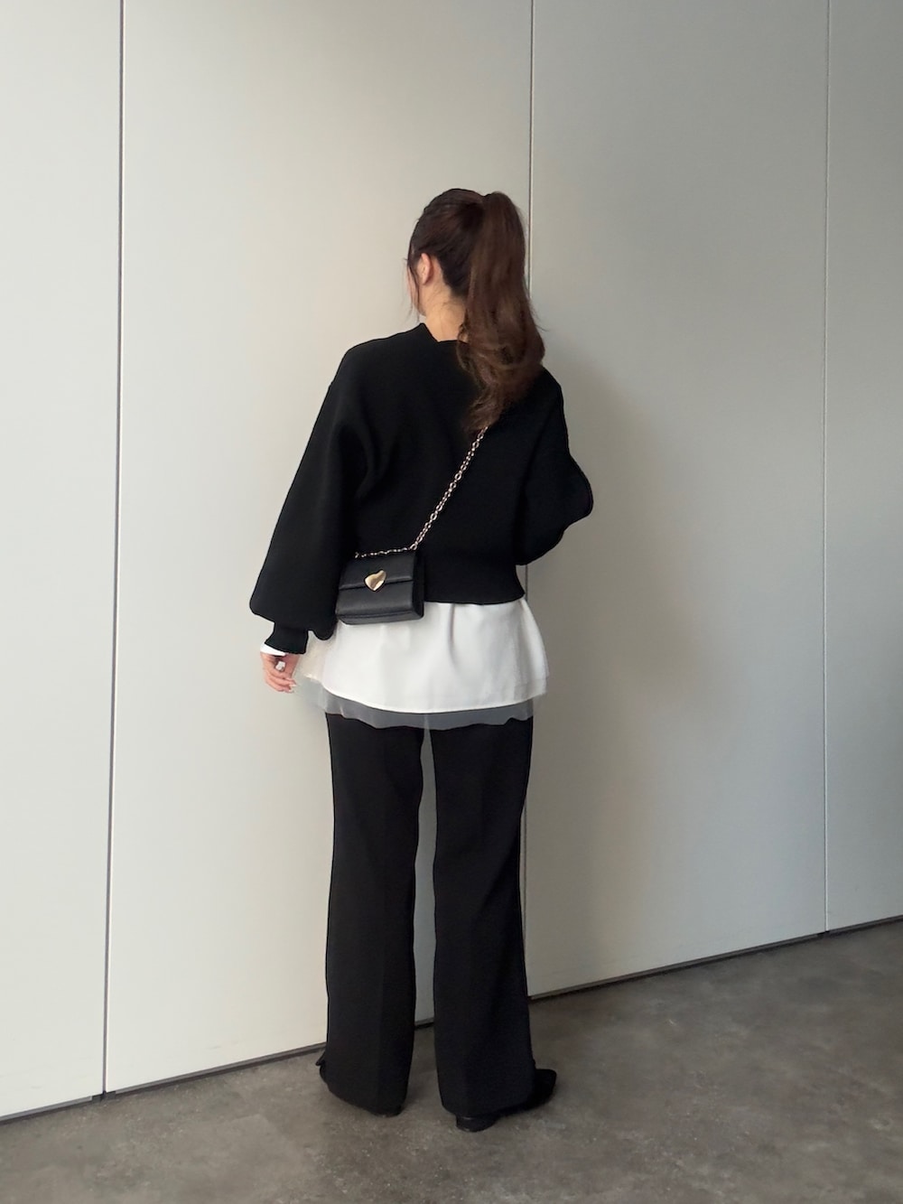 ブラック系のカーディガン/ボレロ、ホワイト系のTシャツ/カットソー、ブラック系のその他パンツを着用したレディースの冬コーディネートの4枚目の写真