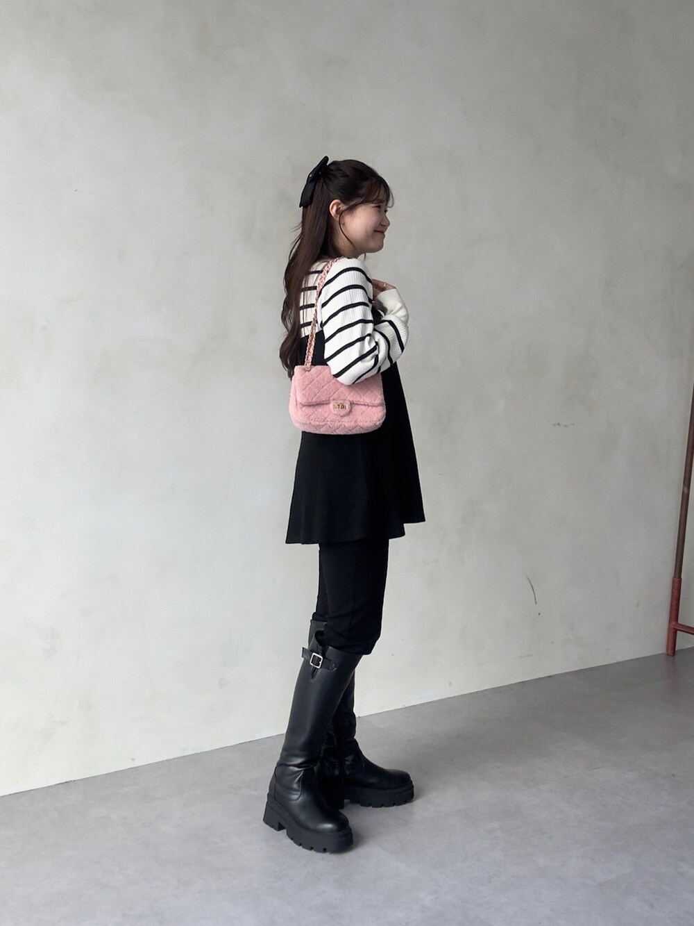 ブラック系のその他パンツ、ブラック系のブーツ、ホワイト系のニット/セーターを着用したレディースの秋コーディネートの3枚目の写真