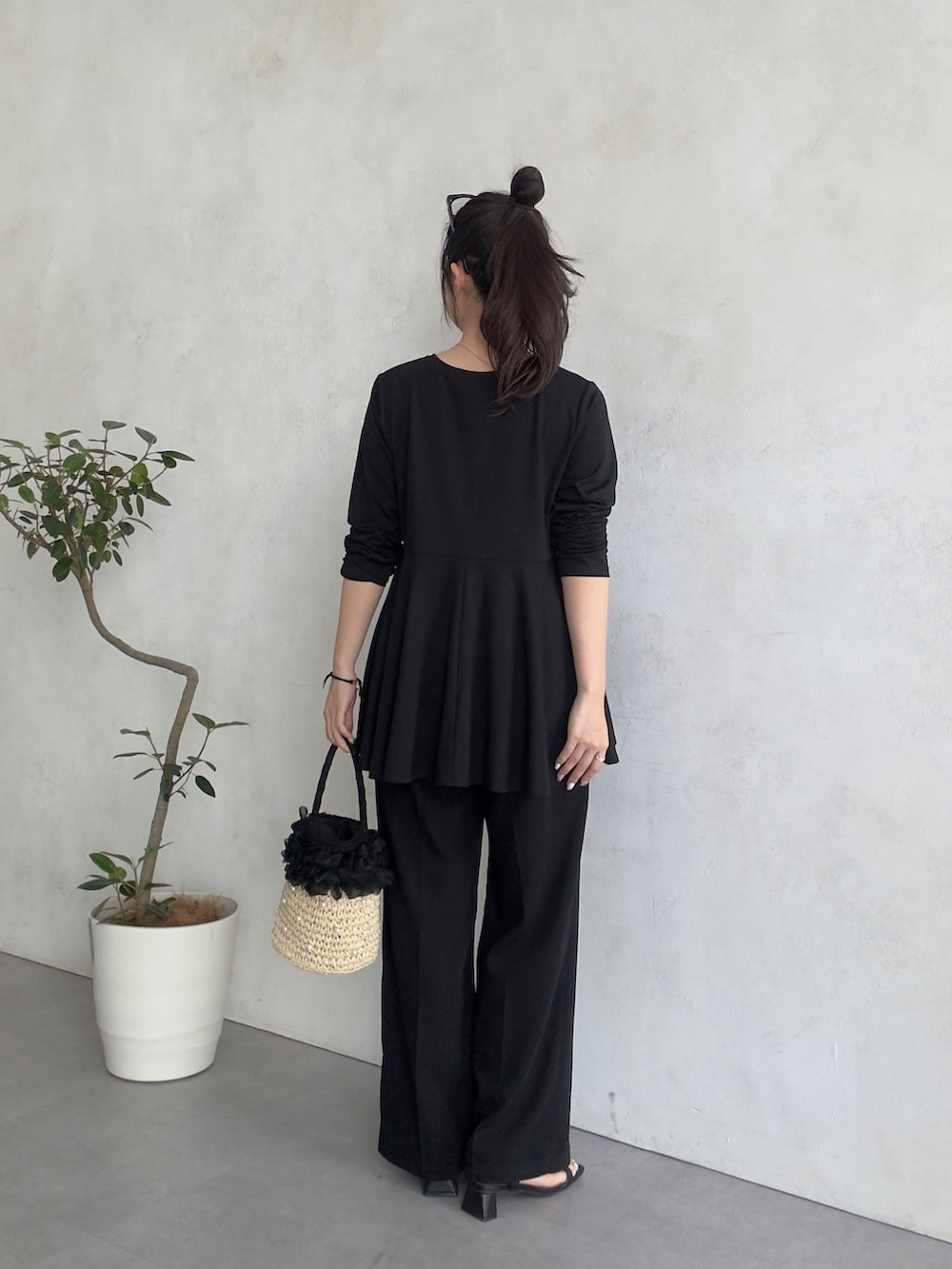 ブラック系のスラックス、ブラック系のサンダル、ブラック系のTシャツ/カットソーを着用したレディースの春コーディネートの3枚目の写真