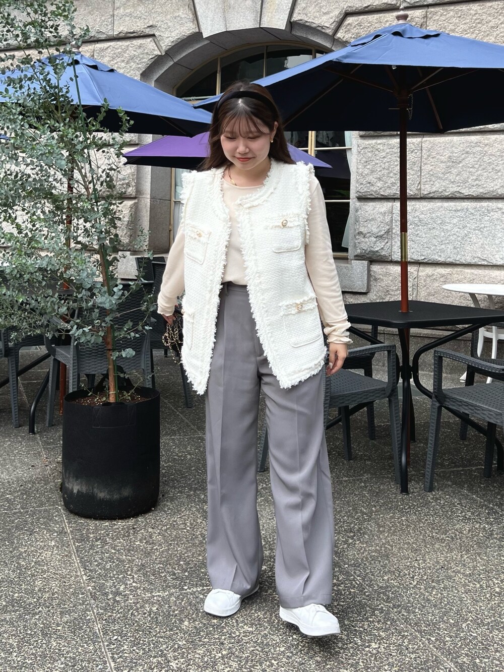 ホワイト系のTシャツ/カットソー、グレー系のスラックス、ホワイト系のベストを着用したレディースの秋コーディネートの2枚目の写真