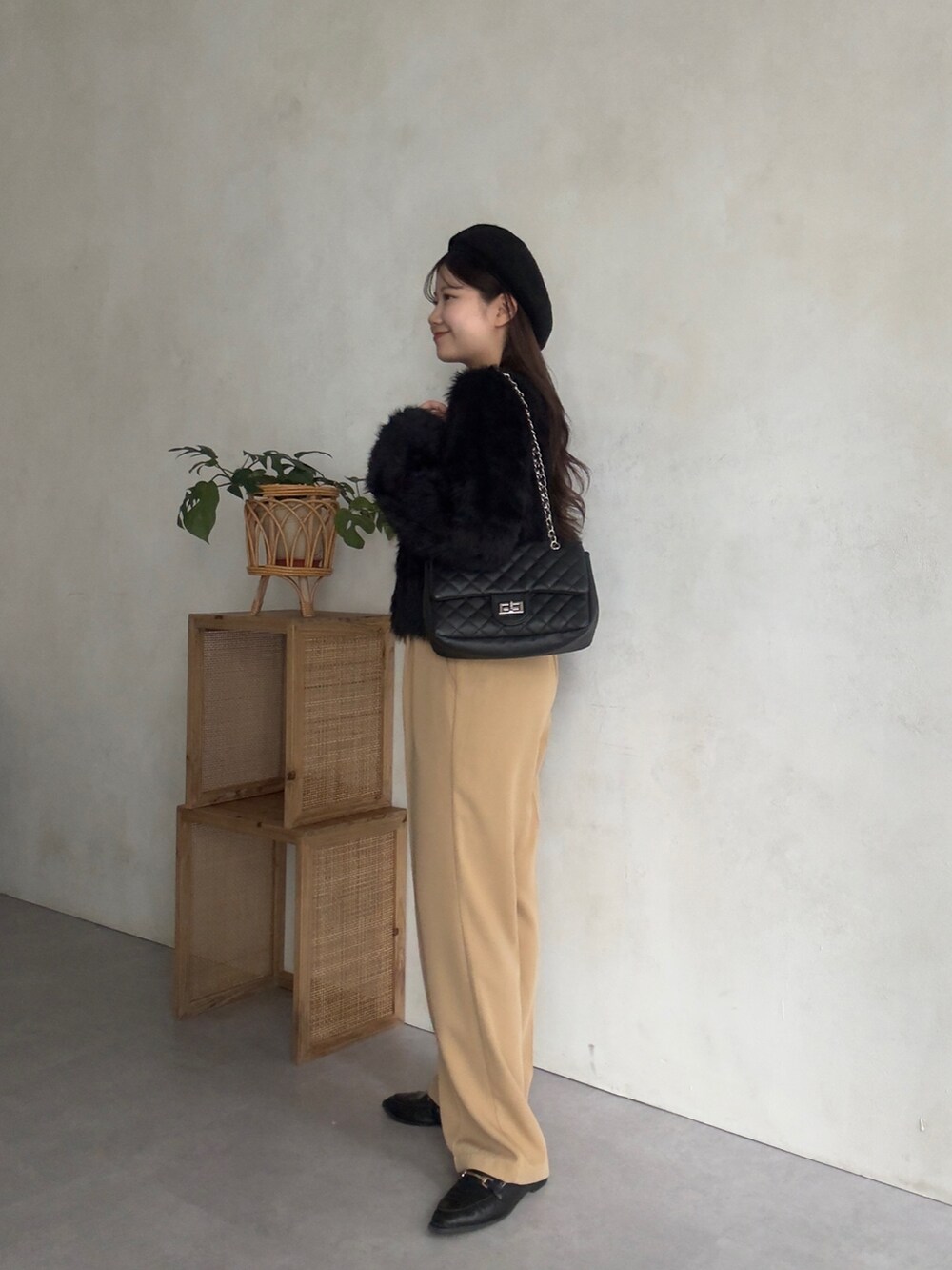 ブラック系のカーディガン/ボレロ、ベージュ系のスラックスを着用したレディースの秋コーディネートの2枚目の写真