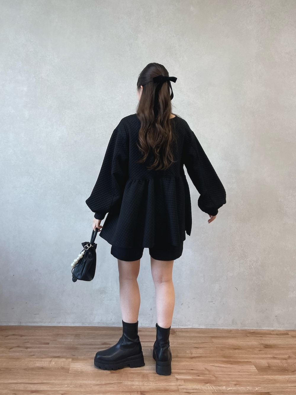 ブラック系のショルダーバッグ、ブラック系のブーツ、ブラック系のその他パンツを着用したレディースの春コーディネートの3枚目の写真