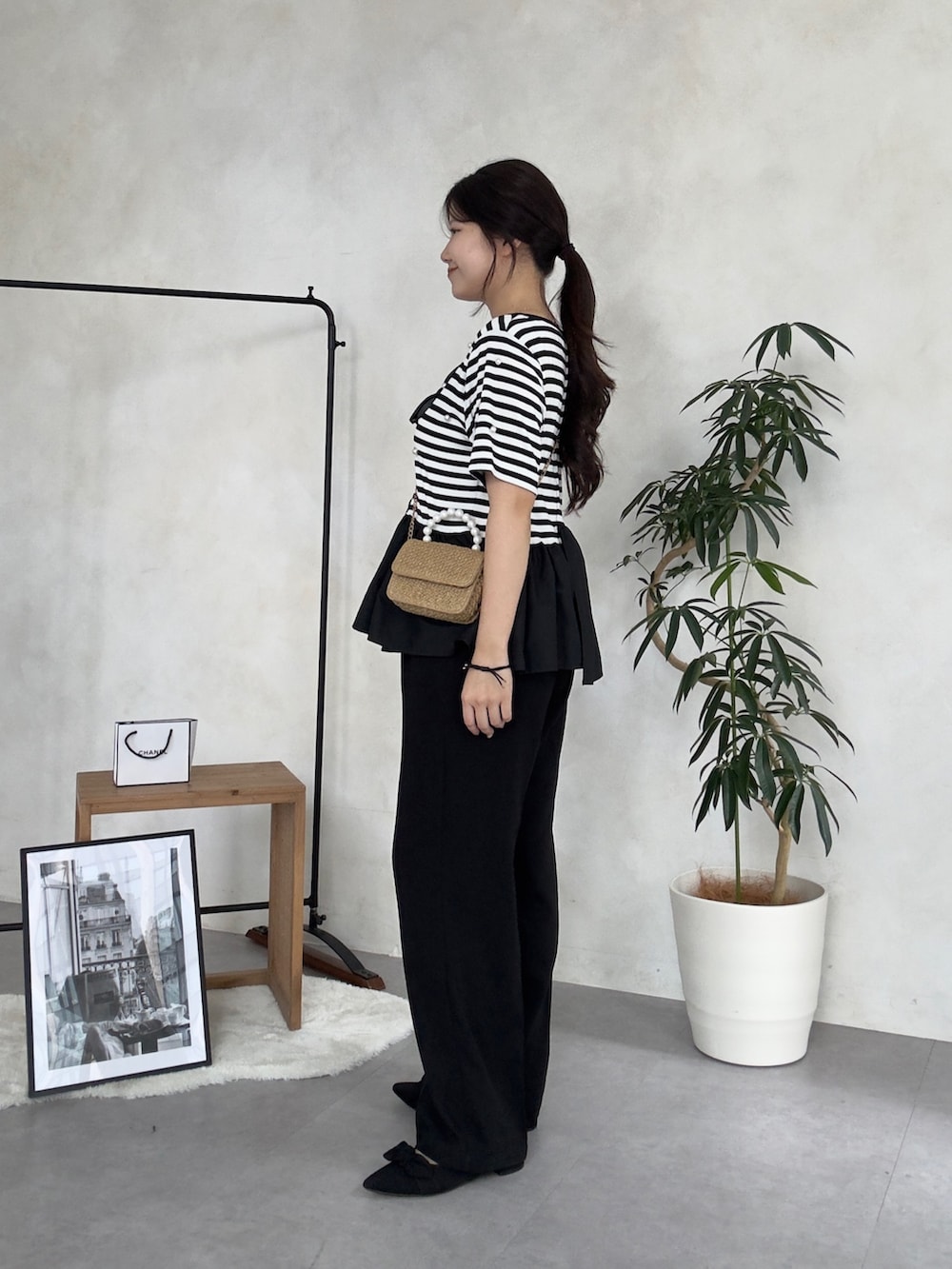 ブラック系のスラックス、ブラック系のパンプス、ブラック系のTシャツ/カットソーを着用したレディースの夏コーディネートの2枚目の写真