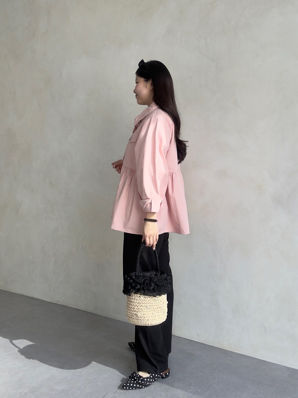 ホワイト系のパンツドレス、ピンク系のブルゾンを着用したレディースの冬コーディネートの2枚目の写真