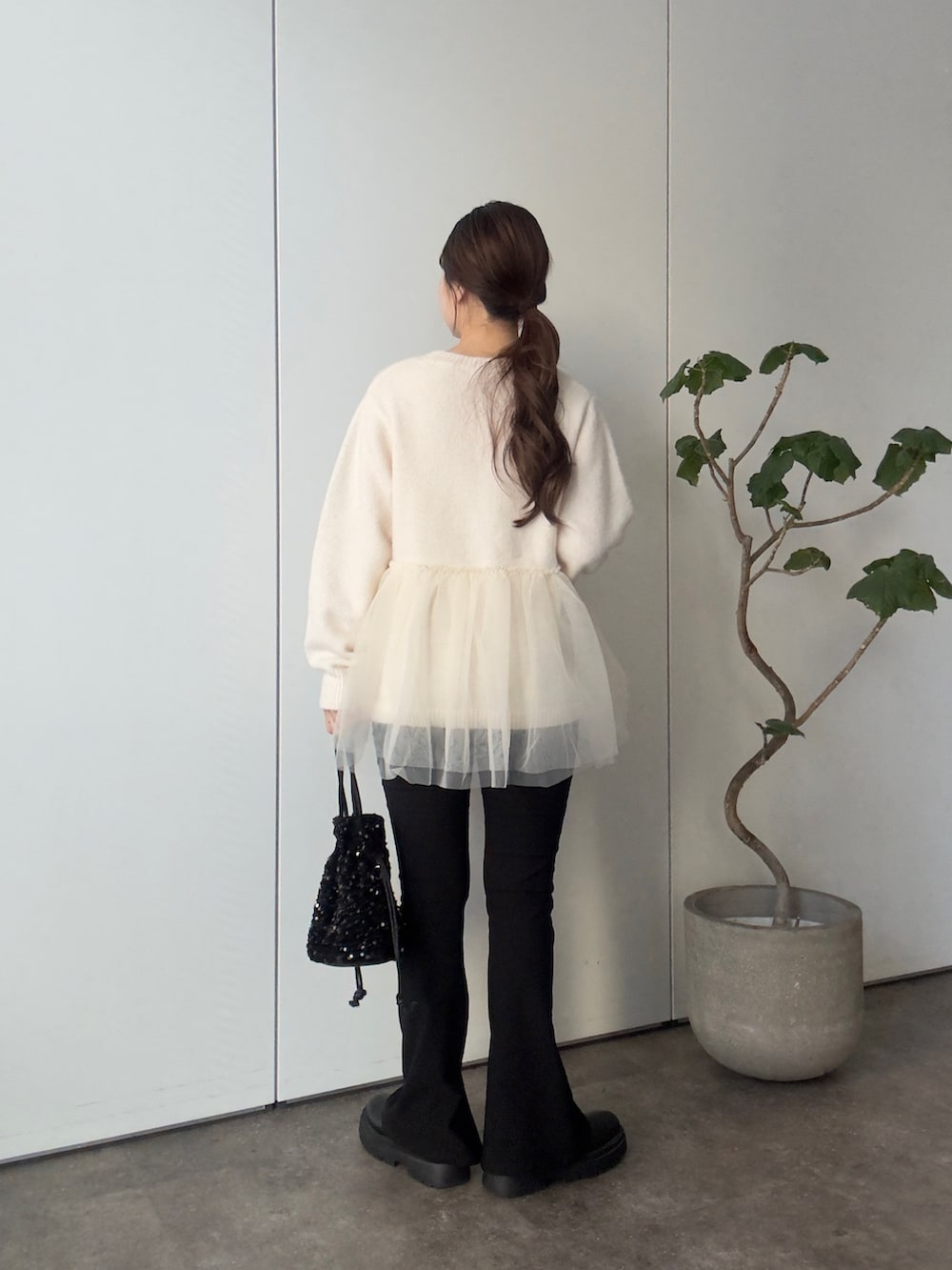 ホワイト系のニット/セーター、ブラック系のショルダーバッグ、ブラック系のその他パンツを着用したレディースの冬コーディネートの3枚目の写真