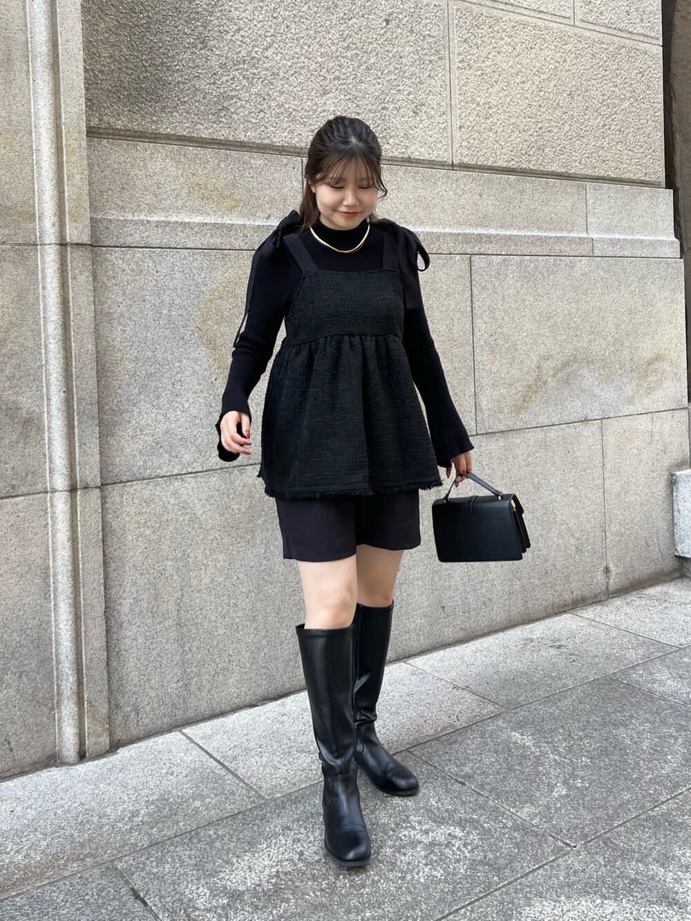 ブラック系のニット/セーター、ブラック系のブーツ、ブラック系のキャミソールを着用したレディースの秋コーディネートの3枚目の写真