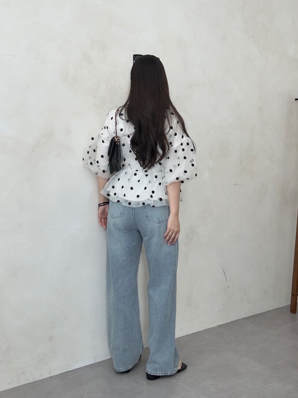 ブラック系のトートバッグ、ホワイト系のシャツ/ブラウス、ブラック系のサンダルを着用したレディースの春コーディネートの2枚目の写真