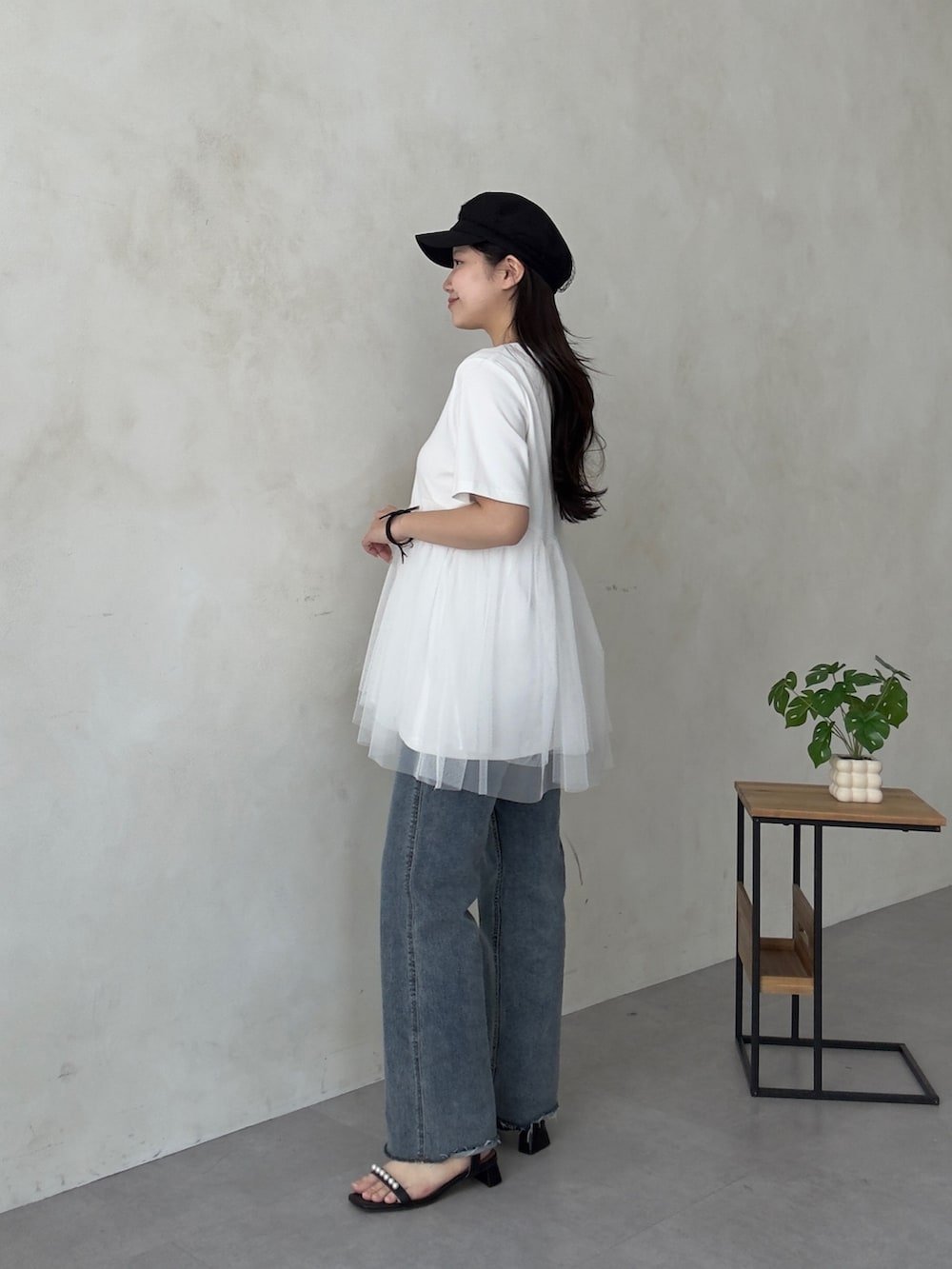 ベージュ系のかごバッグ、ブルー系のデニムパンツ、ブラック系のサンダルを着用したレディースの夏コーディネートの2枚目の写真