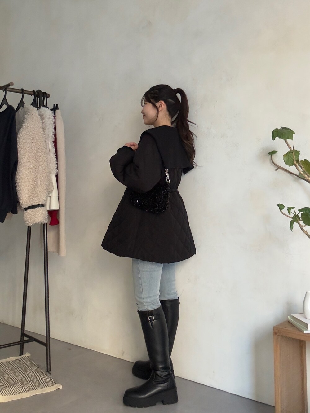 ホワイト系のニット/セーター、ブルー系のデニムパンツ、ブラック系のブーツを着用したレディースの秋コーディネートの2枚目の写真