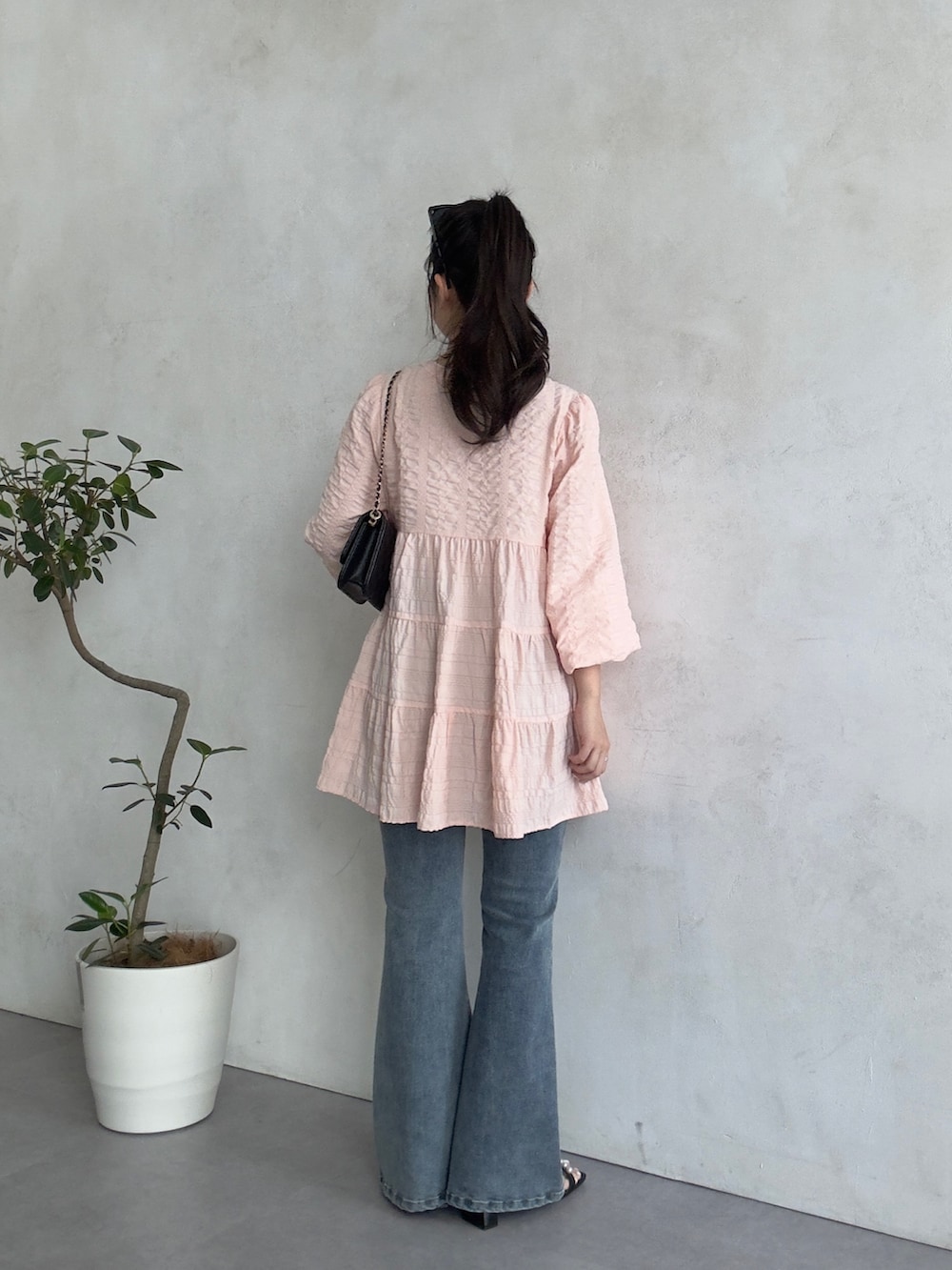 ブラック系のトートバッグ、ブルー系のデニムパンツ、ブラック系のサンダルを着用したレディースの春コーディネートの3枚目の写真