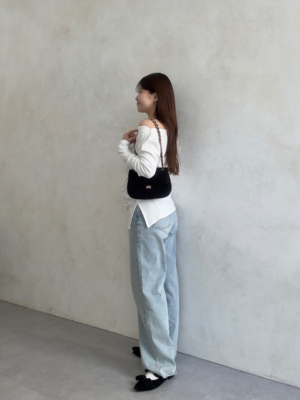 ブルー系のデニムパンツ、ブラック系のショルダーバッグ、ホワイト系のTシャツ/カットソーを着用したレディースの夏コーディネートの2枚目の写真