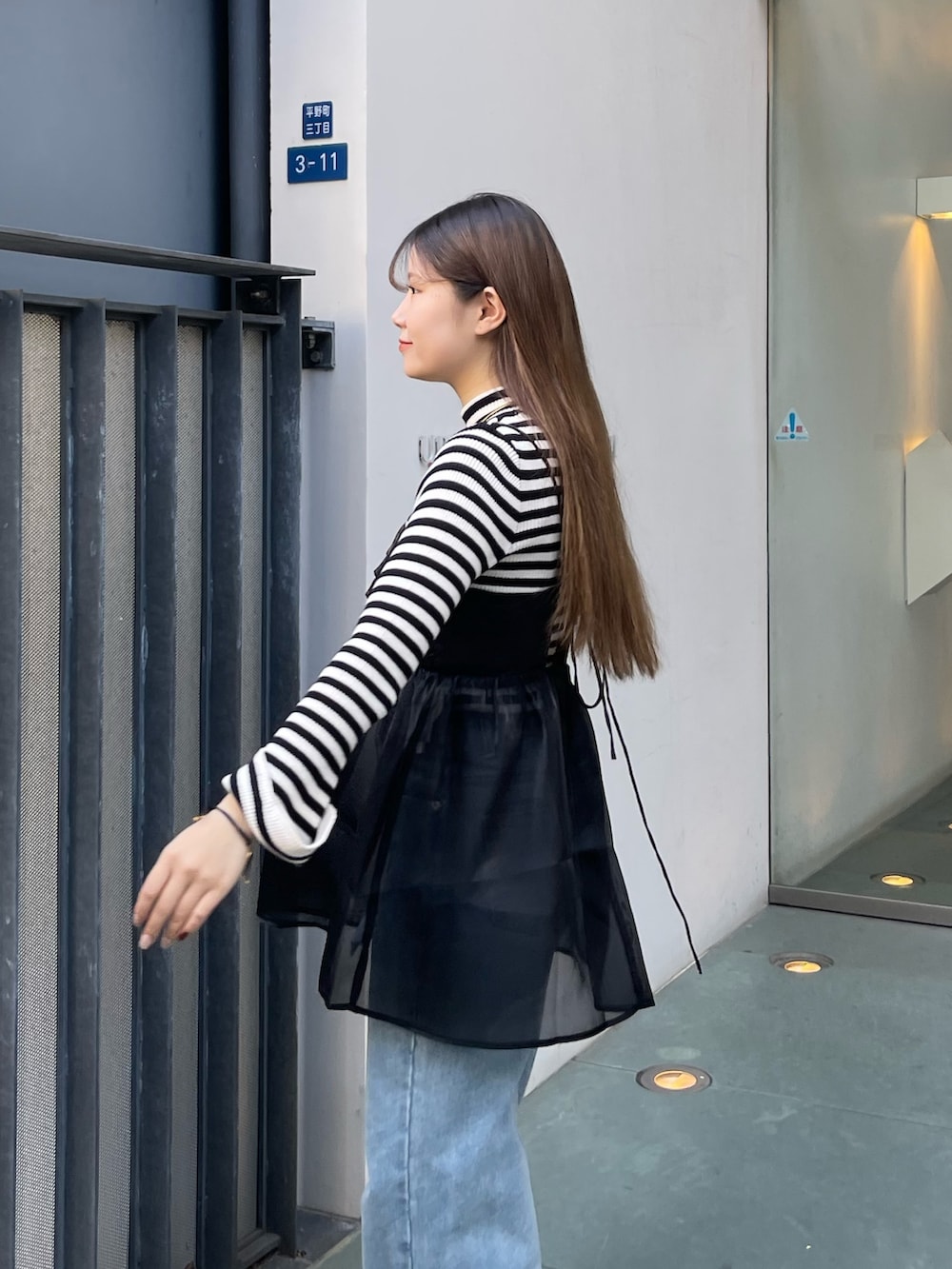 ホワイト系のニット/セーター、ブラック系のショルダーバッグ、ブラック系のキャミソールを着用したレディースの冬コーディネートの2枚目の写真