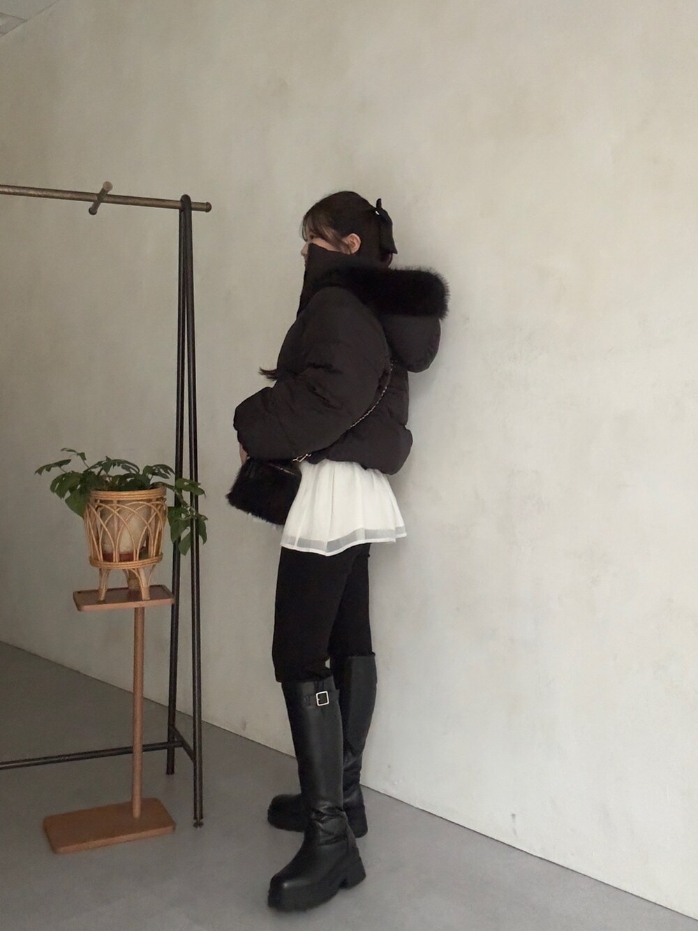 ブラック系のダウンジャケット/コート、ホワイト系のニット/セーター、ブラック系のその他パンツを着用したレディースの秋コーディネートの2枚目の写真