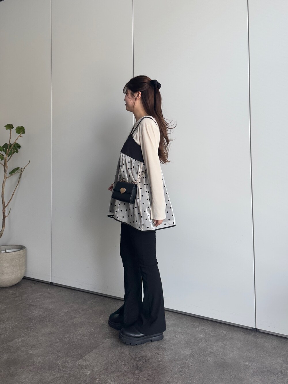 ブラック系のショルダーバッグ、ブラック系のその他パンツ、ホワイト系のTシャツ/カットソーを着用したレディースの冬コーディネートの2枚目の写真