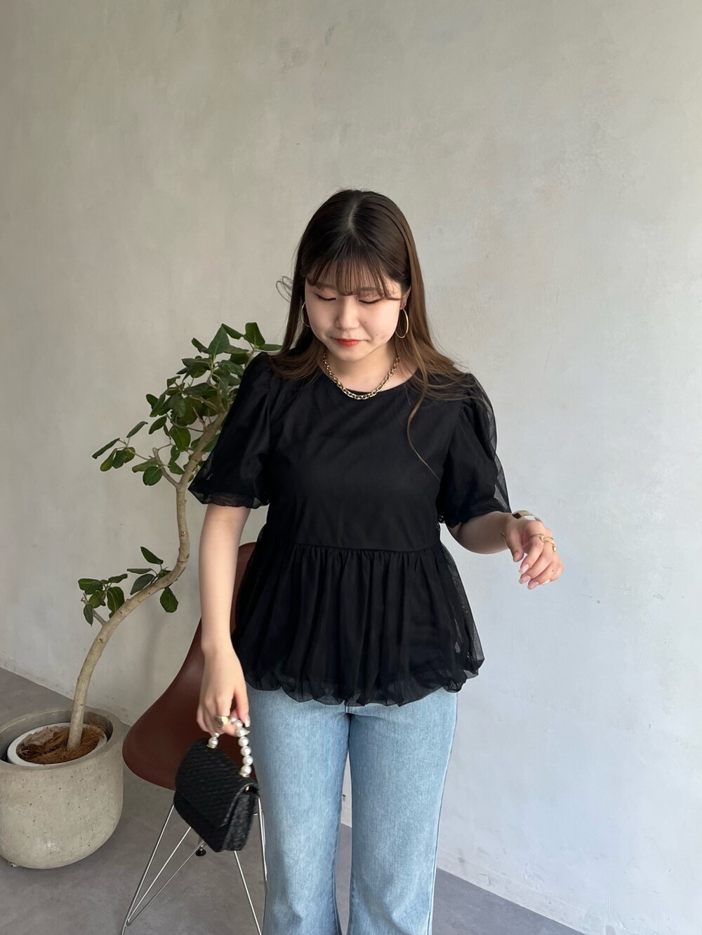 ブルー系のデニムパンツ、ブラック系のシャツ/ブラウス、ゴールド系のネックレスを着用したレディースの春コーディネートの3枚目の写真