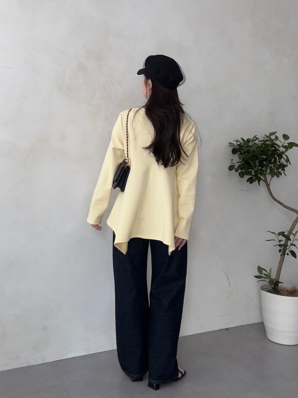 ブラック系のトートバッグ、ブラック系のサンダル、イエロー系のTシャツ/カットソーを着用したレディースの春コーディネートの3枚目の写真