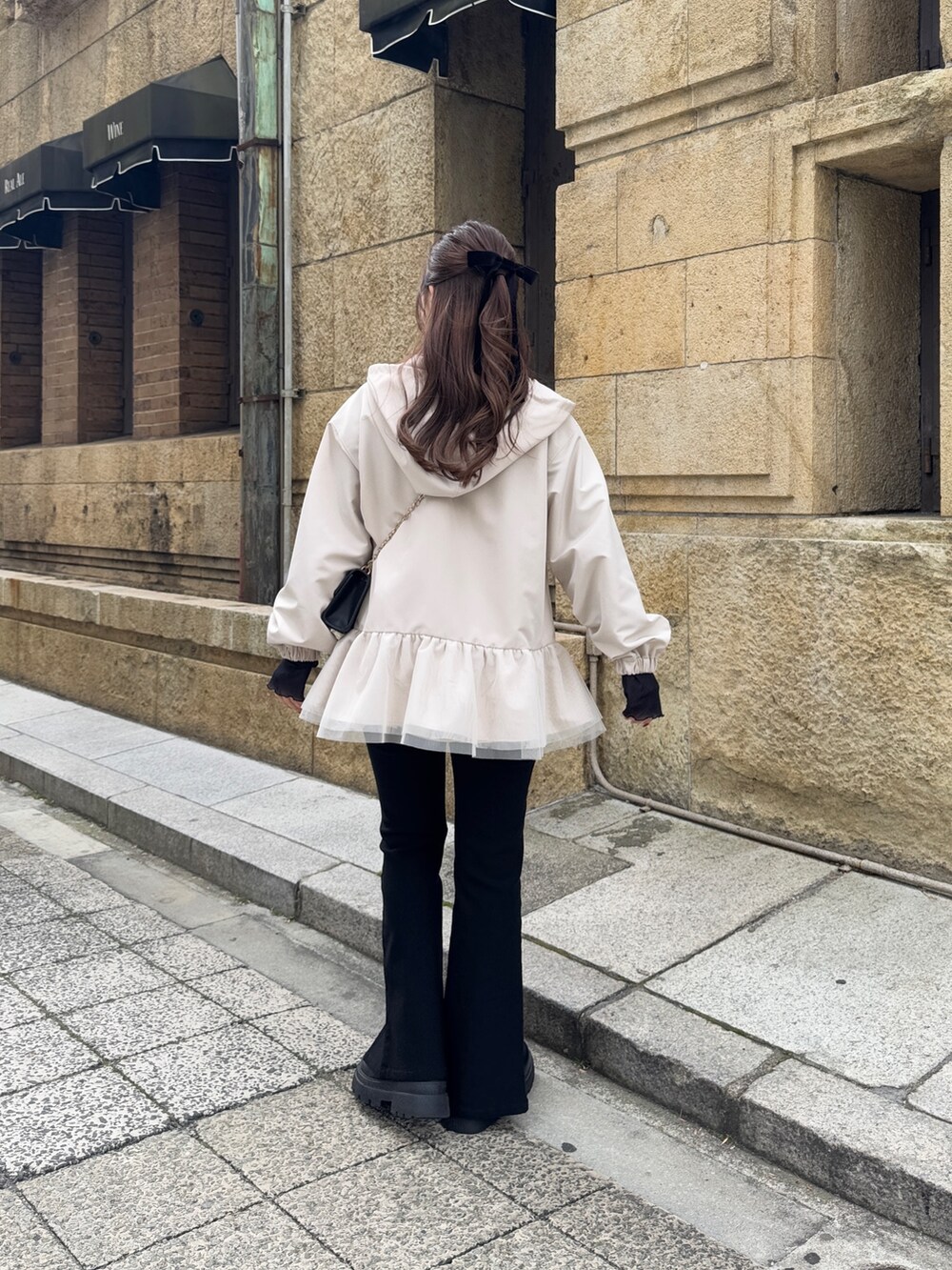 ブラック系のショルダーバッグ、ブラック系のTシャツ/カットソー、ホワイト系のキャミソールを着用したレディースの冬コーディネートの6枚目の写真