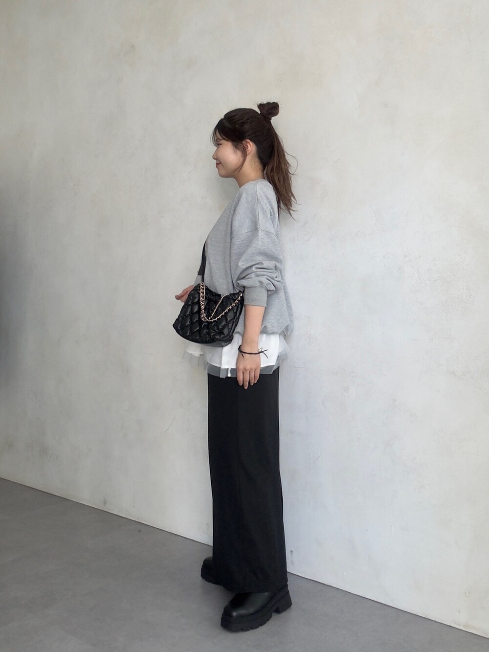 ブラック系のスカート、ブラック系のブーツ、ホワイト系のキャミソールを着用したレディースの夏コーディネートの3枚目の写真