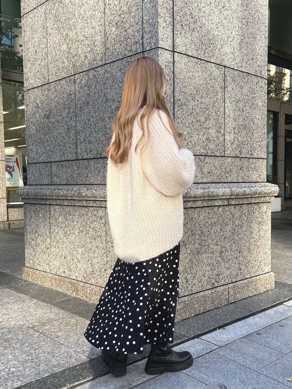 ベージュ系のニット/セーター、ブラック系のブーツ、ブラック系のショルダーバッグを着用したレディースの秋コーディネートの2枚目の写真