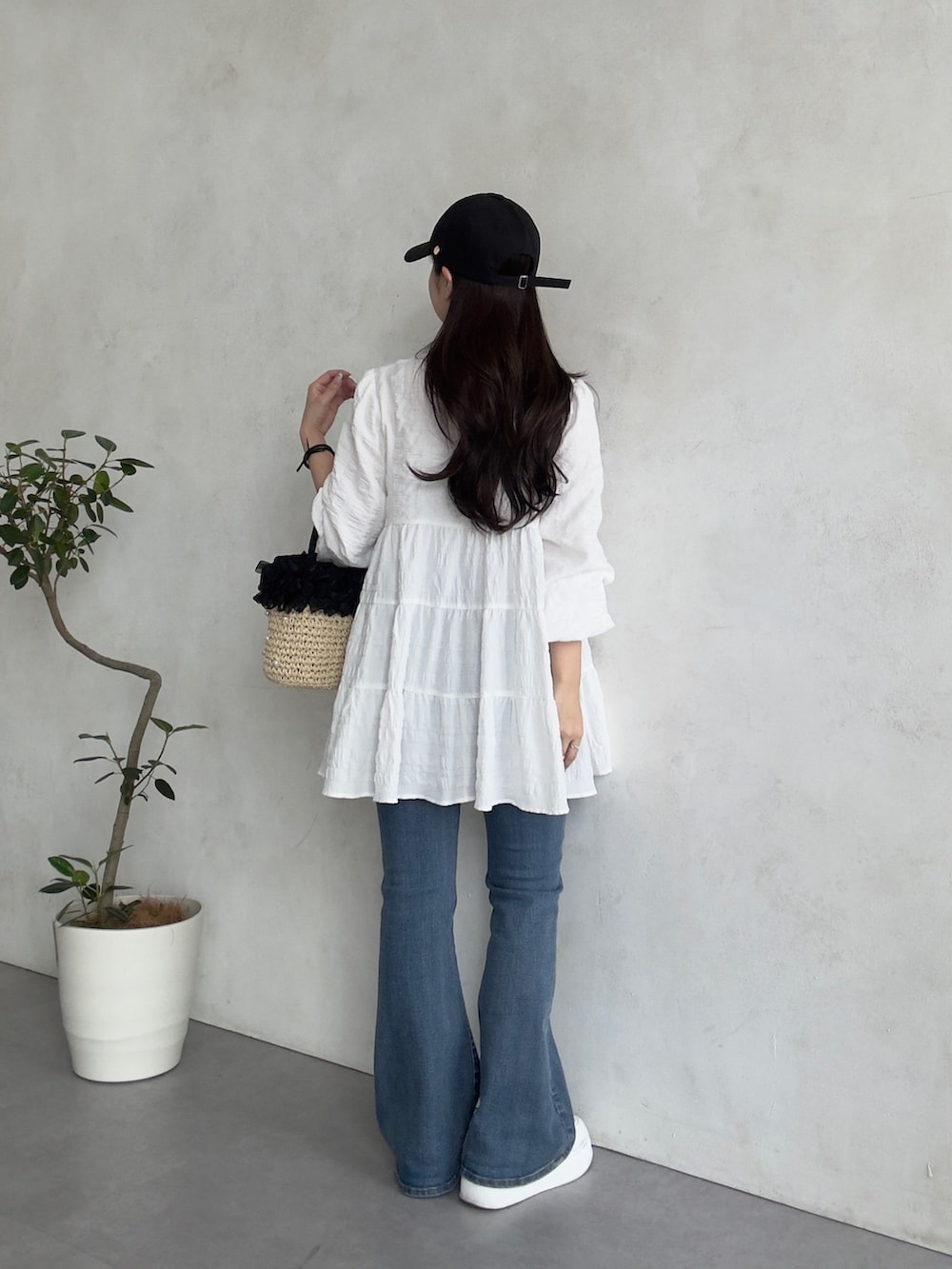 ブルー系のデニムパンツ、ホワイト系のスニーカー、ホワイト系のシャツ/ブラウスを着用したレディースの春コーディネートの3枚目の写真