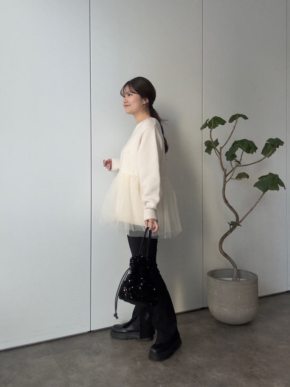 ホワイト系のニット/セーター、ブラック系のショルダーバッグ、ブラック系のその他パンツを着用したレディースの冬コーディネートの2枚目の写真