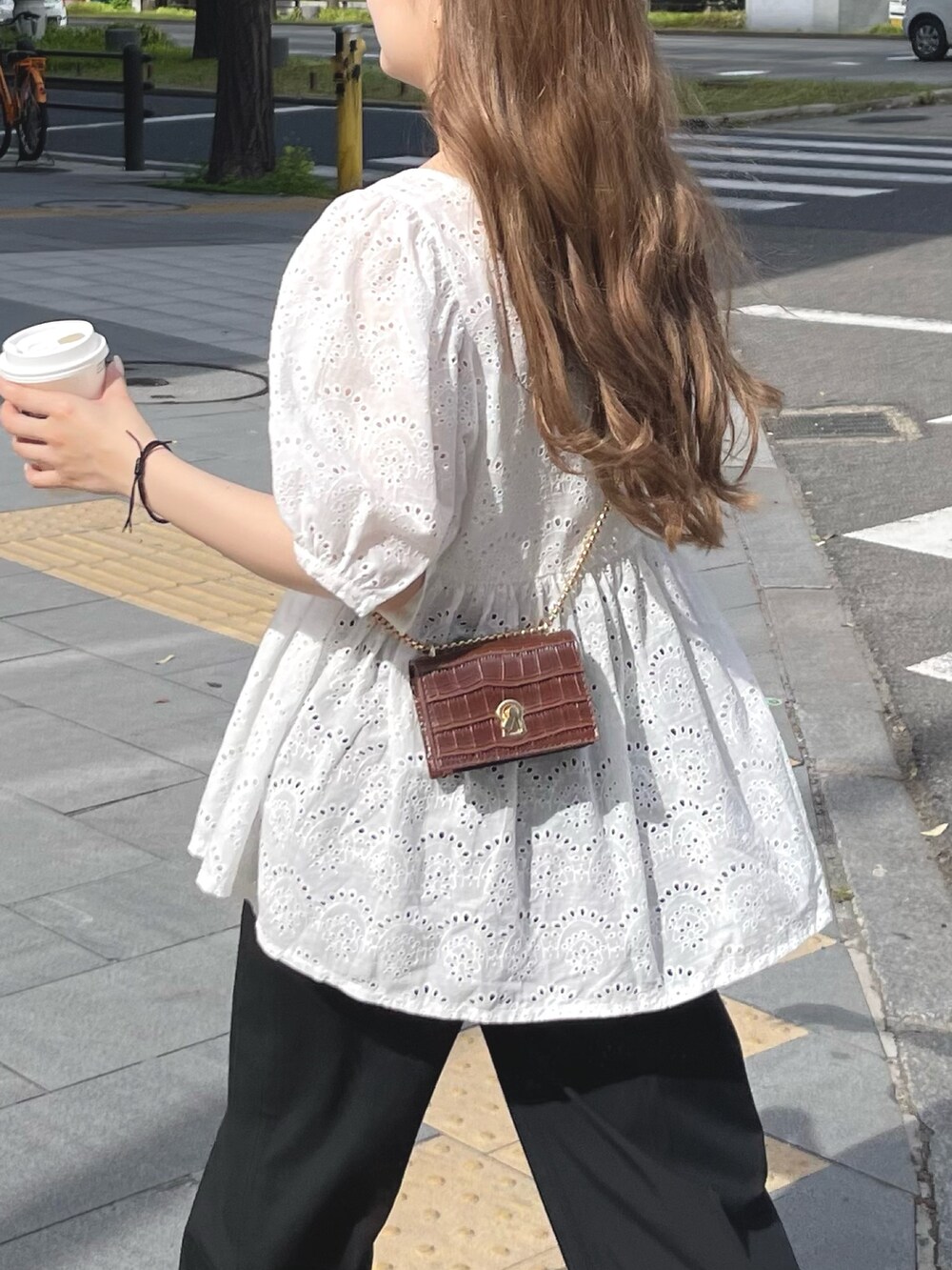 ブラウン系のショルダーバッグ、ホワイト系のシャツ/ブラウス、ゴールド系のネックレスを着用したレディースの春コーディネートの3枚目の写真