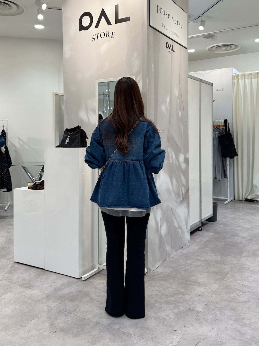 ブルー系のデニムジャケット、シルバー系のショルダーバッグ、ホワイト系のTシャツ/カットソーを着用したレディースの春コーディネートの3枚目の写真