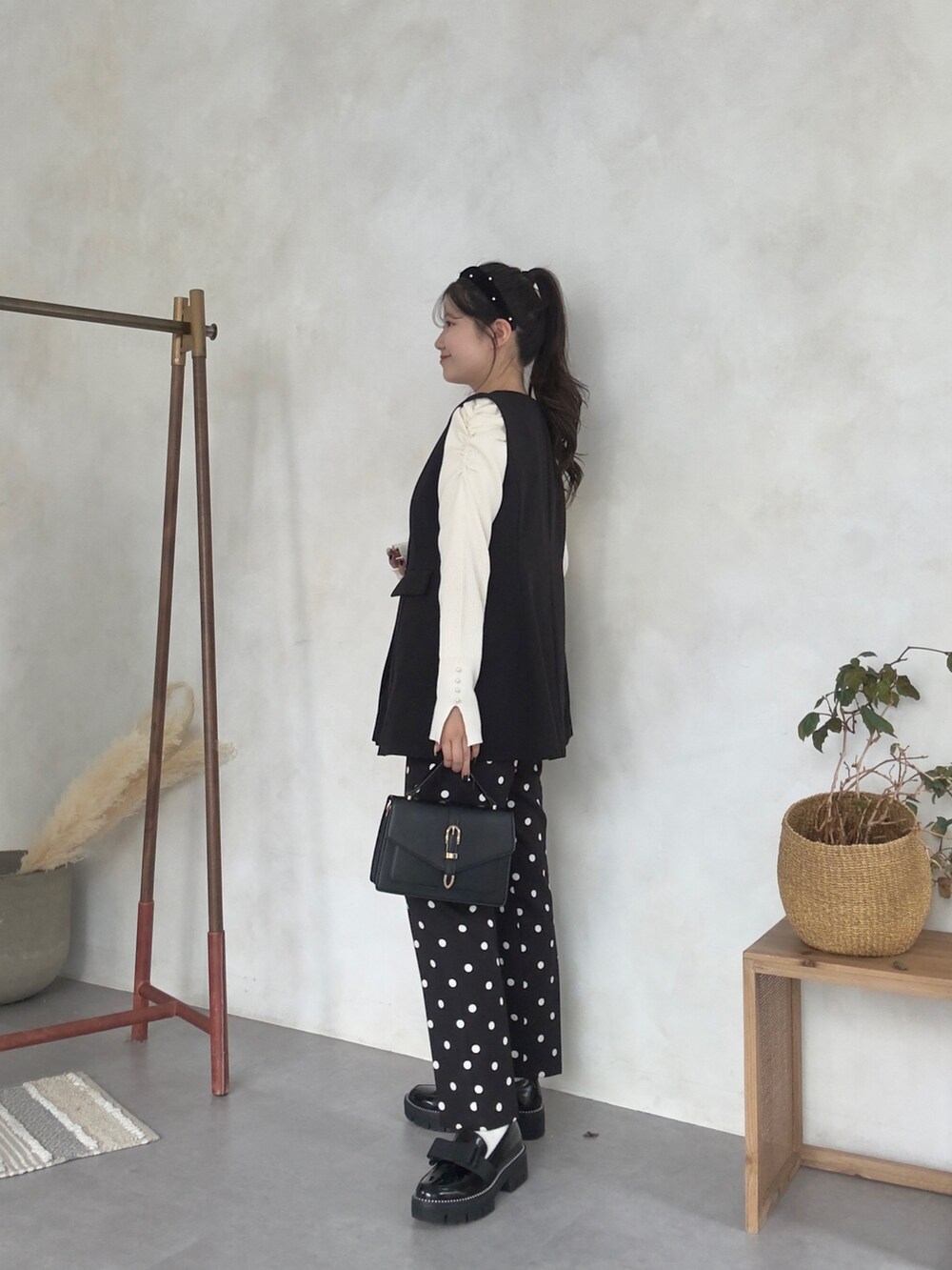 ホワイト系のニット/セーター、ブラック系のその他パンツ、ブラック系のローファーを着用したレディースの秋コーディネートの2枚目の写真