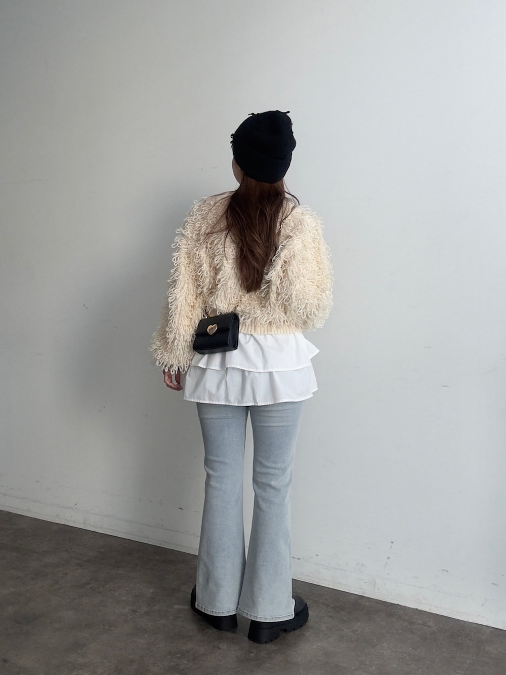 ブルー系のデニムパンツ、ブラック系のブーツ、ホワイト系のカーディガン/ボレロを着用したレディースの夏コーディネートの3枚目の写真