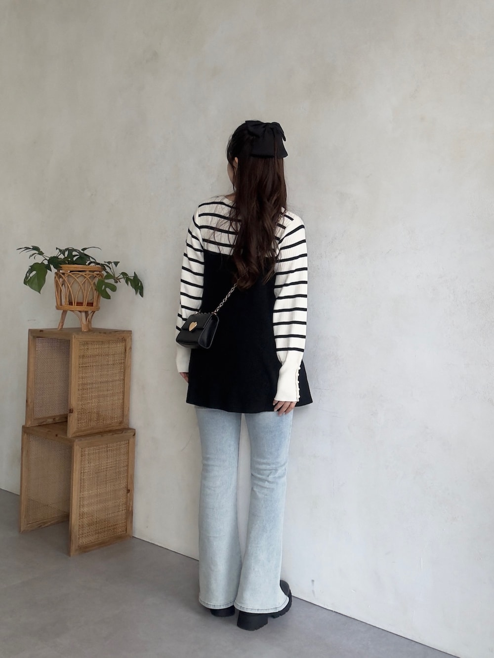 ホワイト系のニット/セーター、ブルー系のデニムパンツ、ブラック系のブーツを着用したレディースの秋コーディネートの3枚目の写真