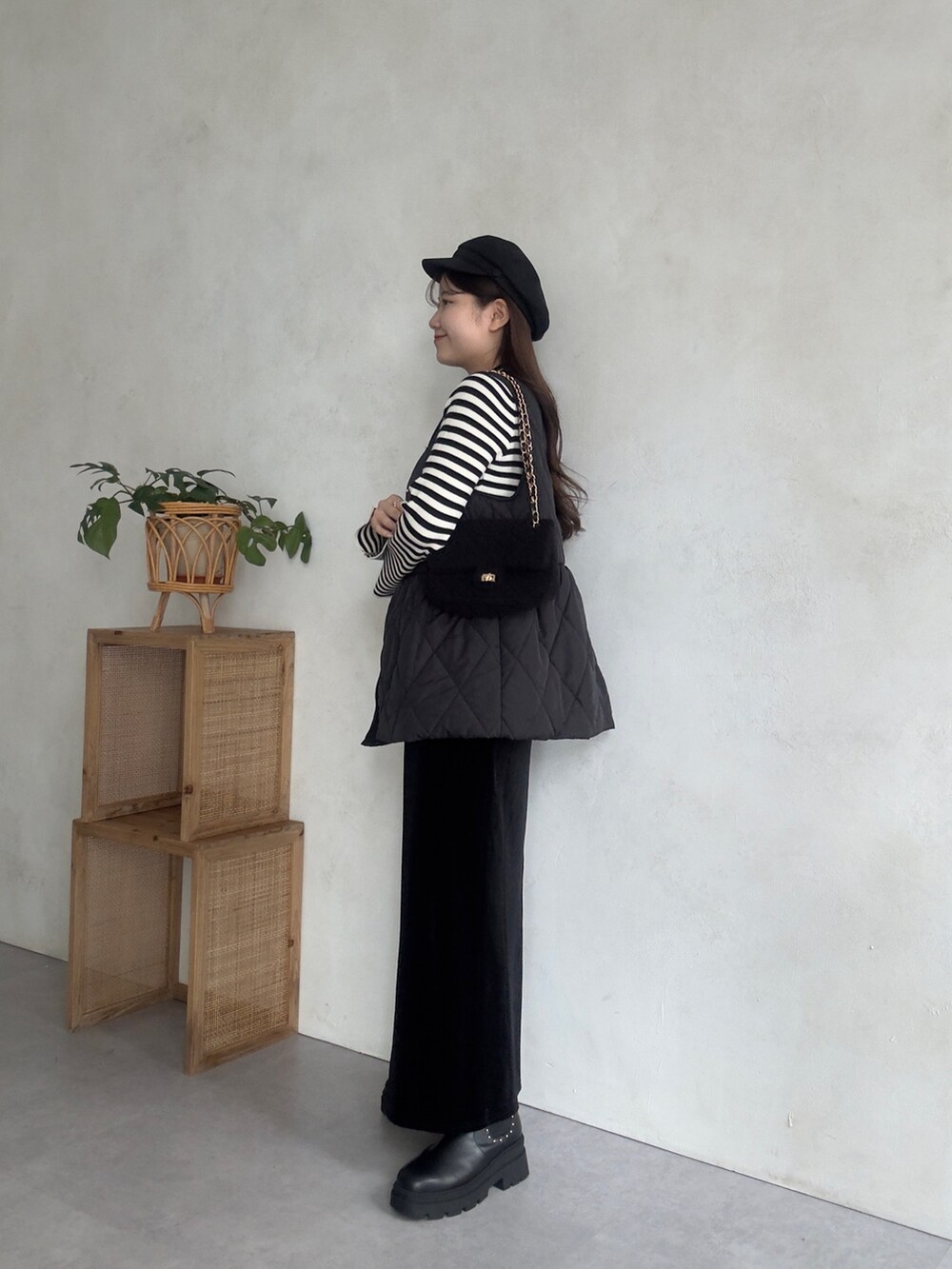 ブラック系のショルダーバッグ、ブラック系のベスト、ブラック系のスカートを着用したレディースの秋コーディネートの2枚目の写真