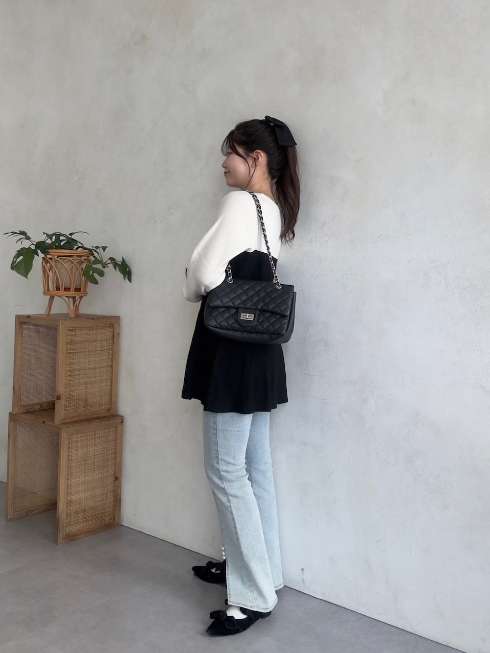 ブルー系のデニムパンツ、ホワイト系のニット/セーターを着用したレディースの秋コーディネートの2枚目の写真