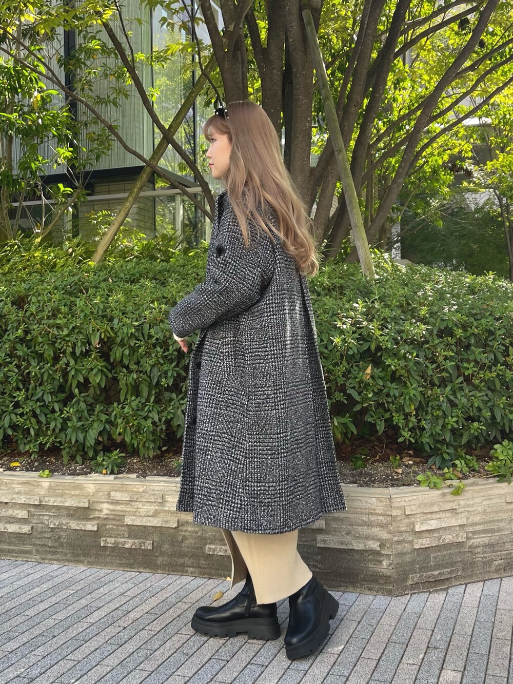 ホワイト系のニット/セーター、ベージュ系のセットアップ、ブラック系のブーツを着用したレディースの秋コーディネートの4枚目の写真