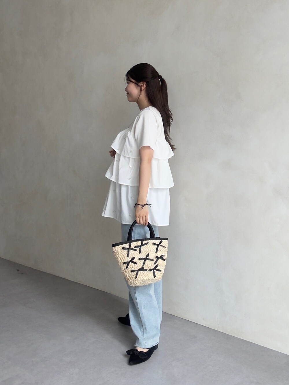 ホワイト系のTシャツ/カットソー、ブルー系のデニムパンツ、ブラック系のパンプスを着用したレディースの春コーディネートの2枚目の写真
