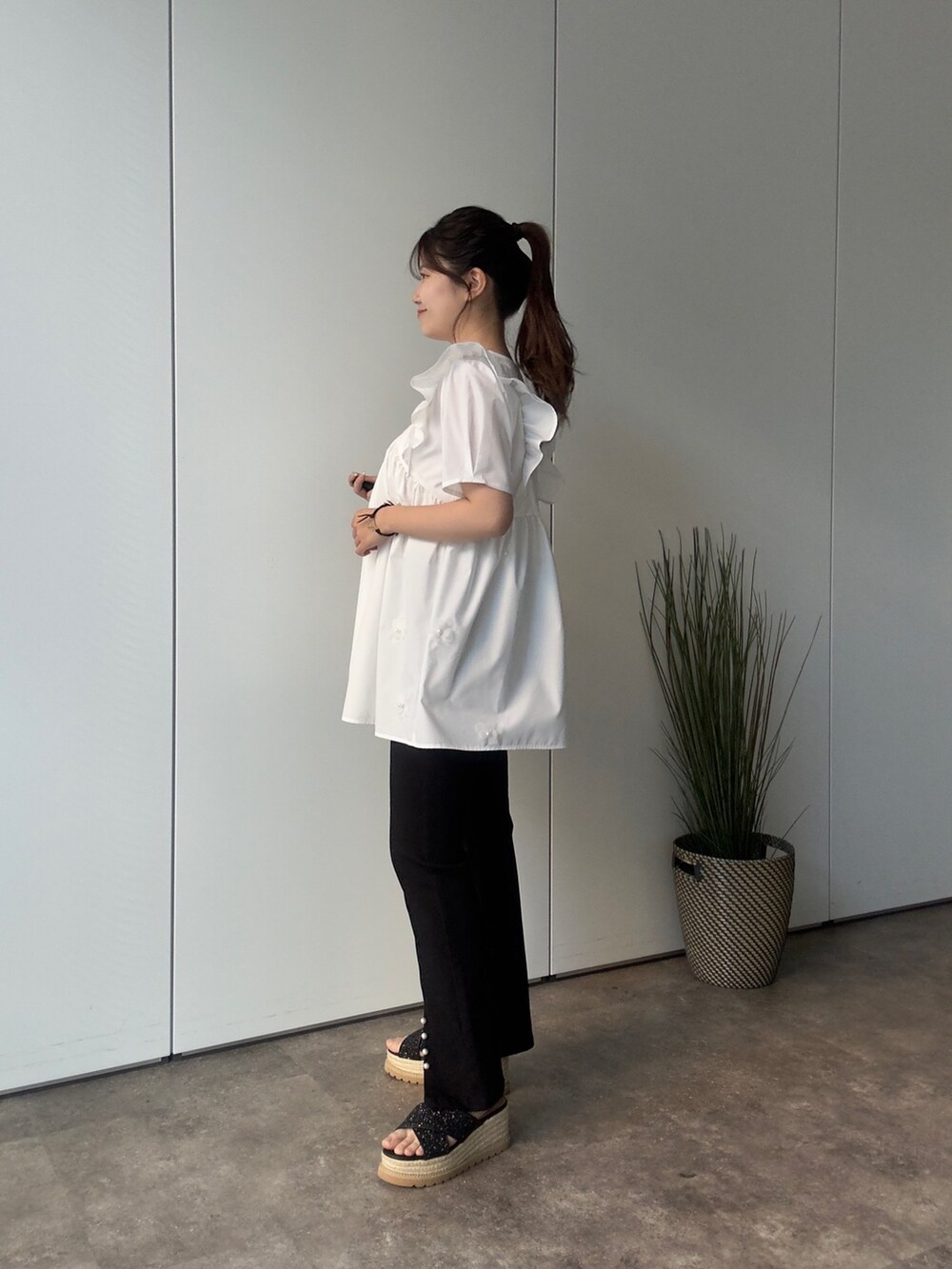 ブラック系のかごバッグ、ブラック系のサンダル、ホワイト系のシャツ/ブラウスを着用したレディースの夏コーディネートの2枚目の写真