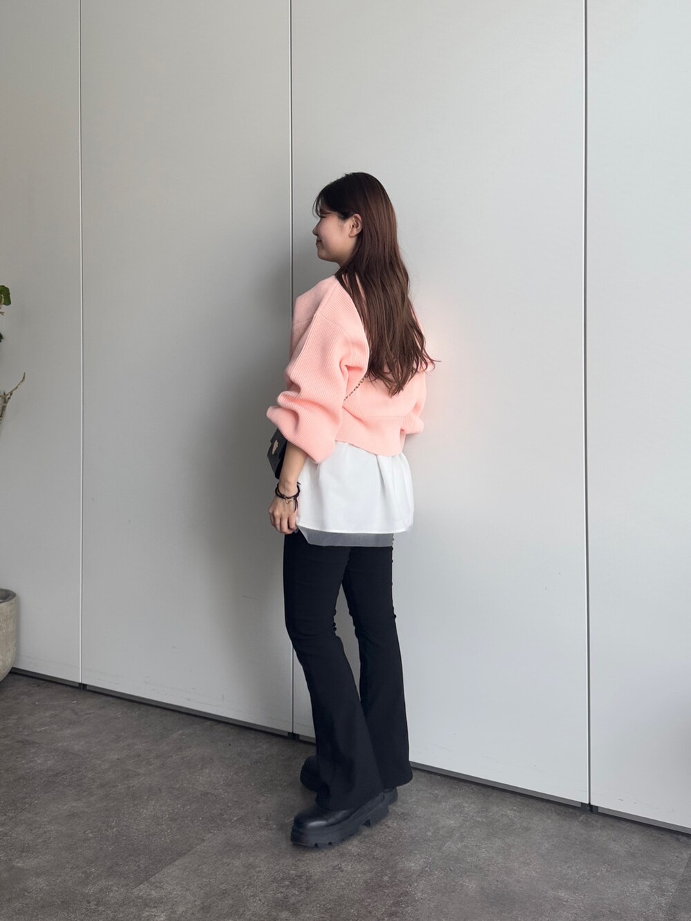 ブラック系のショルダーバッグ、ブラック系のその他パンツ、ピンク系のカーディガン/ボレロを着用したレディースの冬コーディネートの2枚目の写真