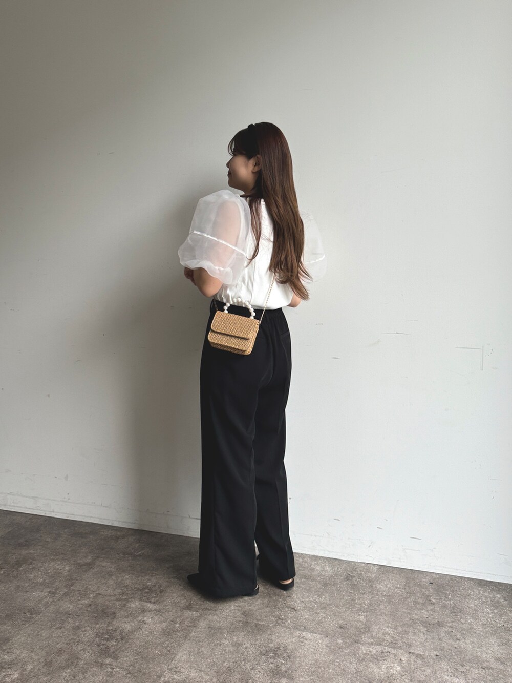 ブラック系のスラックス、ベージュ系のショルダーバッグ、ブラック系のパンプスを着用したレディースの夏コーディネートの2枚目の写真