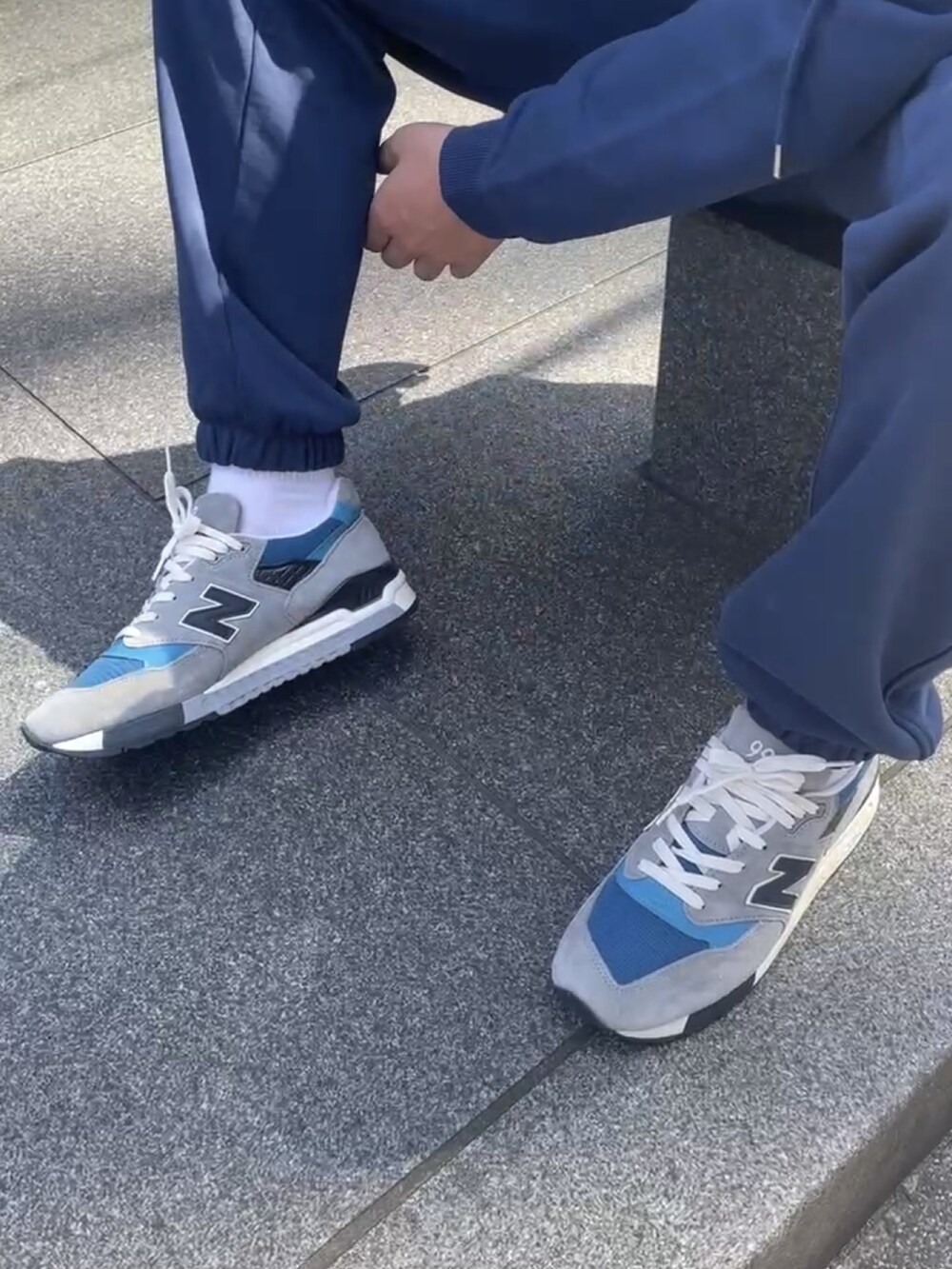 ブルー系のスニーカー、ブルー系のキャップを着用したメンズの夏コーディネートの4枚目の写真