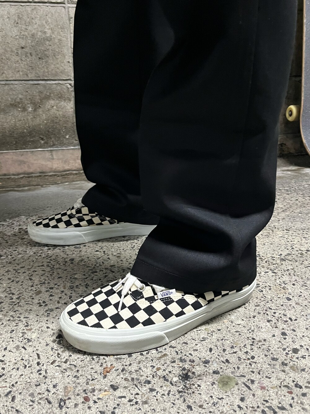 ブラック系のTシャツ/カットソー、ブラック系のチノパンツ、ホワイト系のスニーカーを着用したメンズの夏コーディネートの4枚目の写真