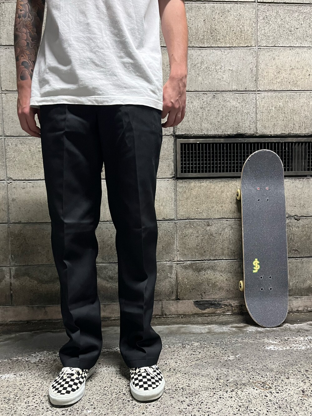 ブラック系のTシャツ/カットソー、ブラック系のチノパンツ、ホワイト系のスニーカーを着用したメンズの夏コーディネートの5枚目の写真