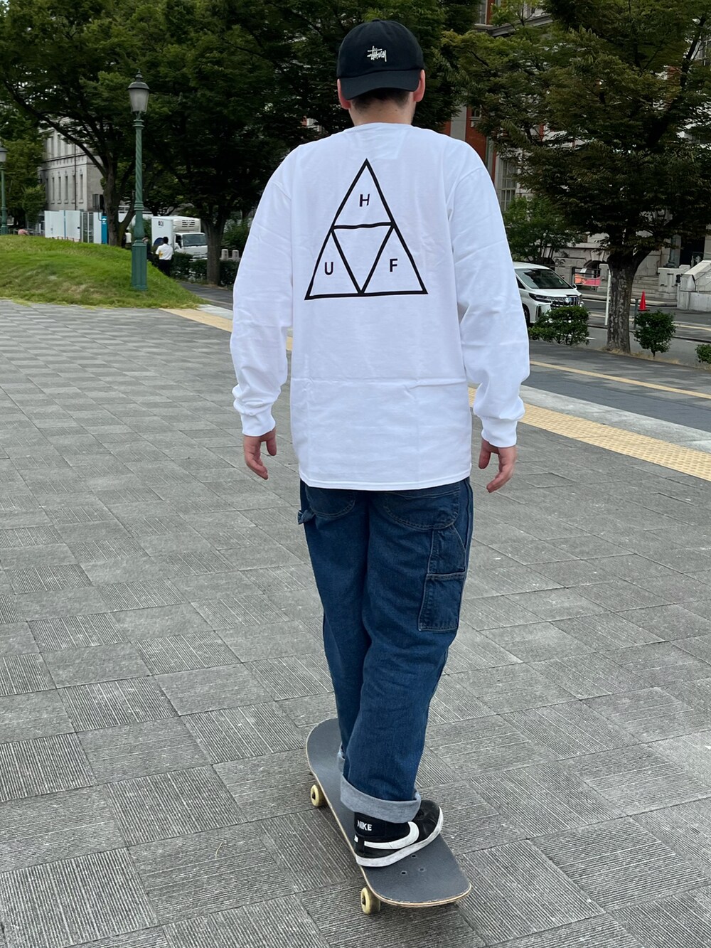 ホワイト系のTシャツ/カットソー、ブルー系のデニムパンツ、ブラック系のスニーカーを着用したメンズの夏コーディネートの2枚目の写真