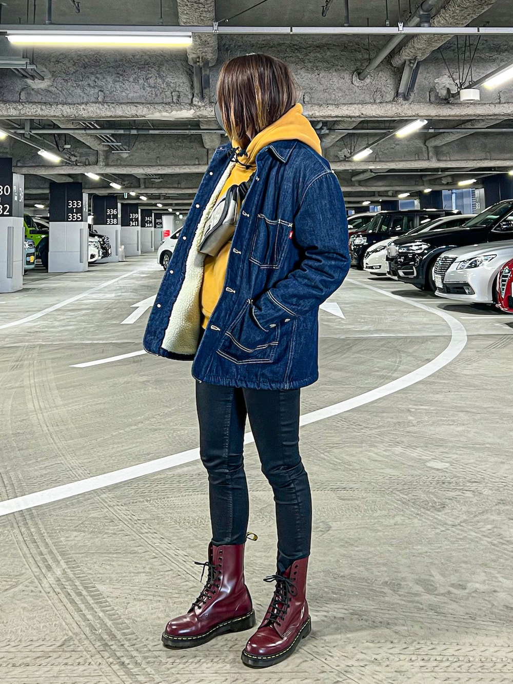 イエロー系のパーカー、ブルー系のデニムジャケット、ブラック系のデニムパンツを着用したレディースの冬コーディネートの2枚目の写真