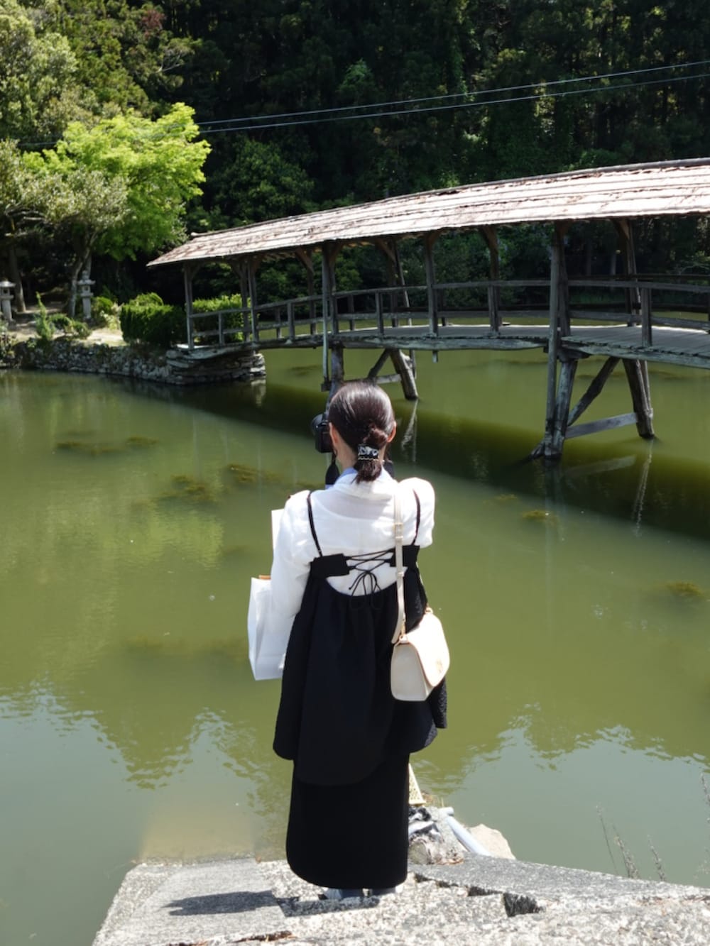 ブラック系のワンピース、ブラック系のスカート、ホワイト系のスニーカーを着用したレディースの春コーディネートの2枚目の写真