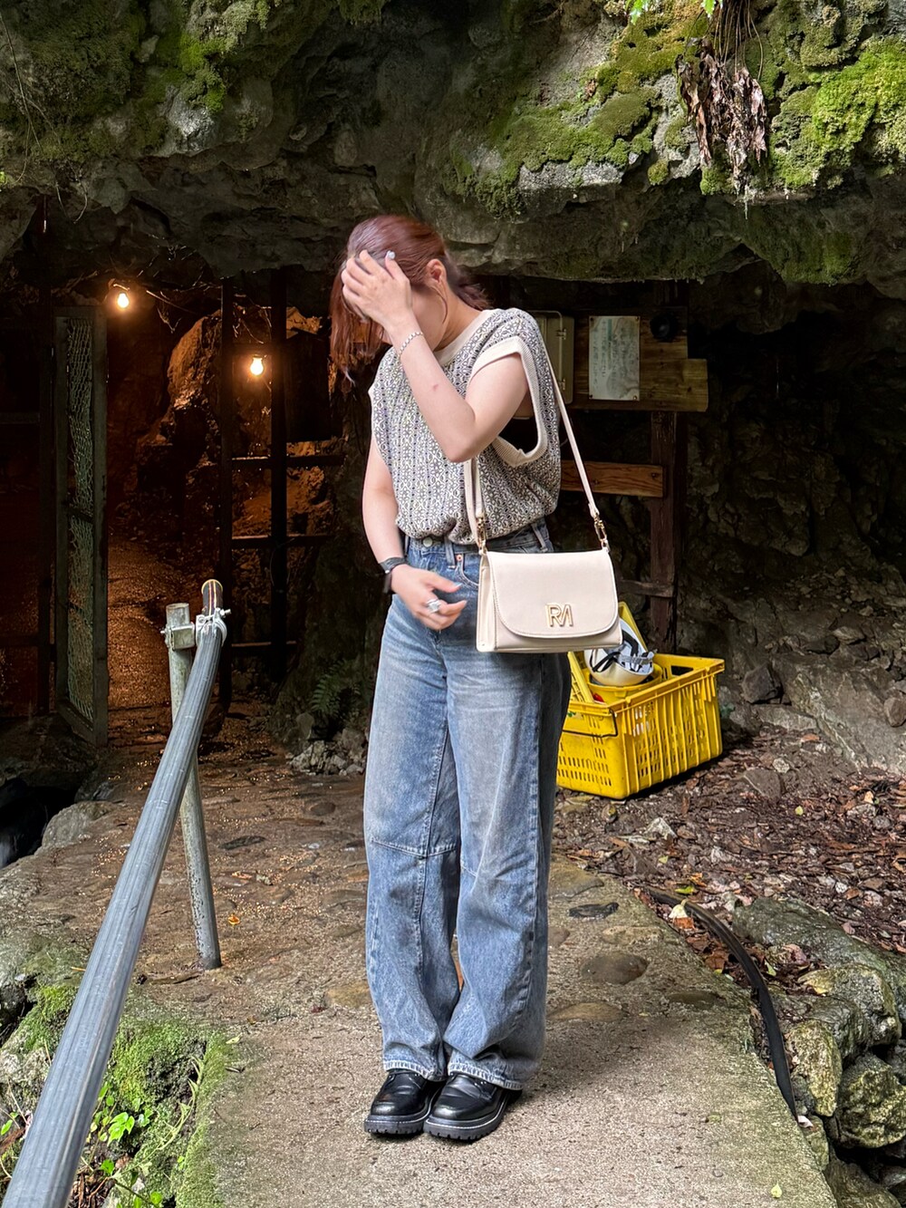 ブラック系のベスト、ブラック系のブーツ、ブルー系のデニムパンツを着用したレディースの夏コーディネートの2枚目の写真