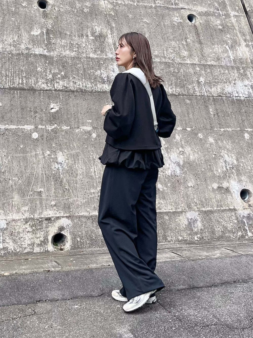 ブラック系のアンサンブル、ホワイト系のボディバッグ/ウエストポーチ、ピンク系の口紅/リップティント/グロスを着用したレディースの秋コーディネートの3枚目の写真