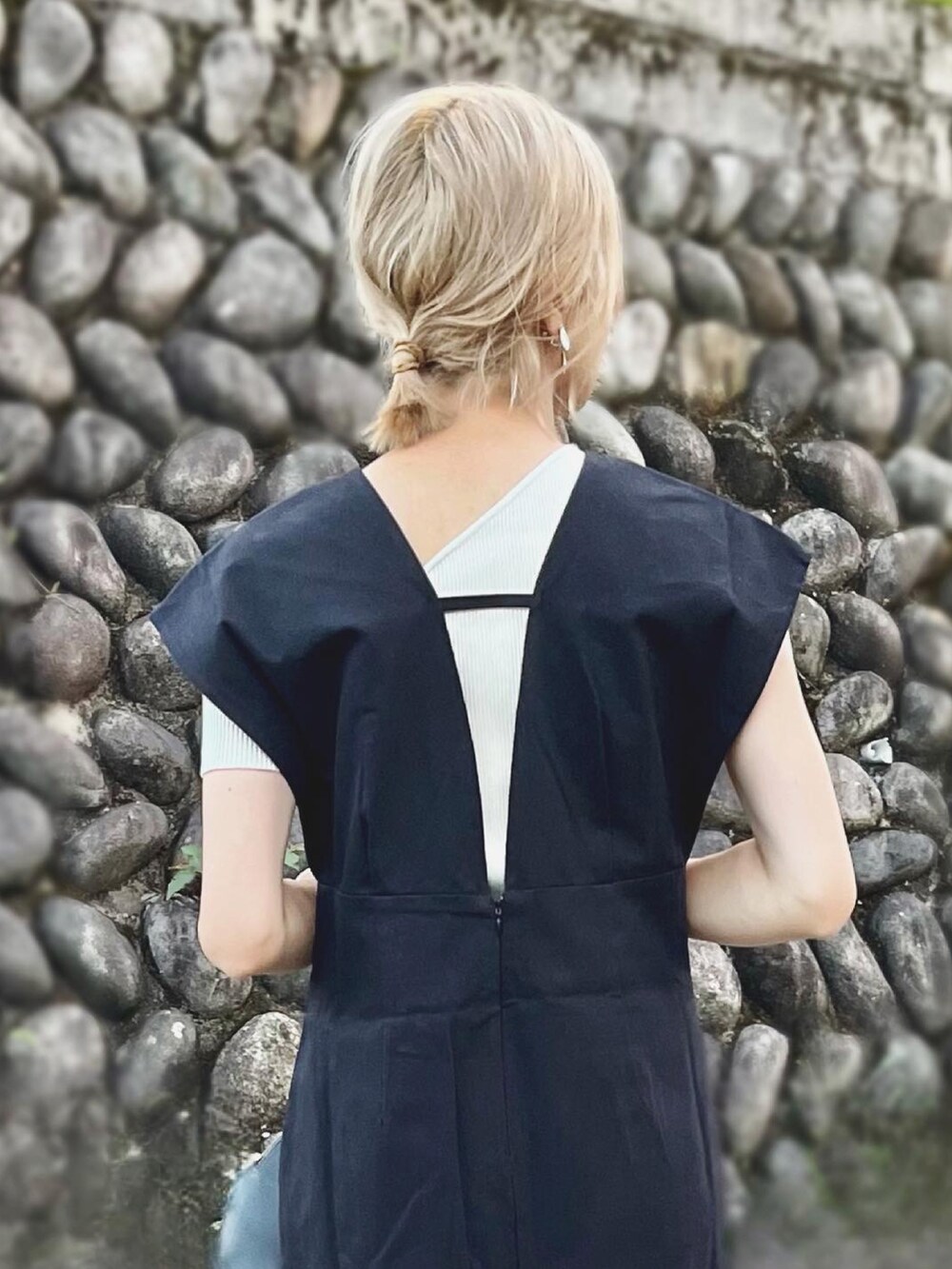 ブラック系のジャンパースカート、ブラック系のローファー、ホワイト系のニット/セーターを着用したレディースの夏コーディネートの2枚目の写真