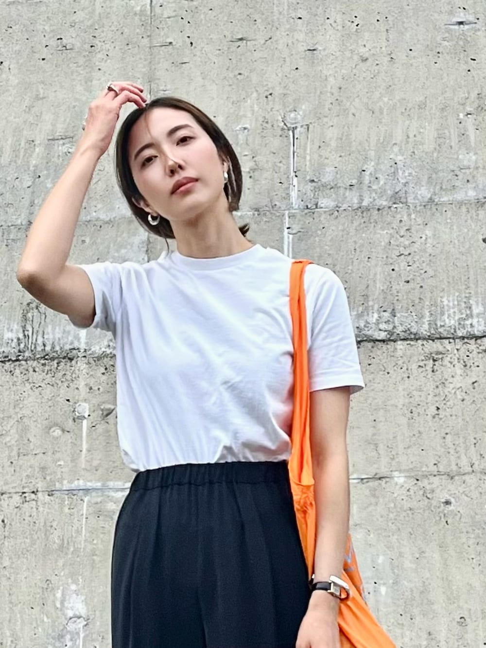 ブルー系のTシャツ/カットソー、ブラック系のスラックス、ブラック系のサンダルを着用したレディースの春コーディネートの2枚目の写真