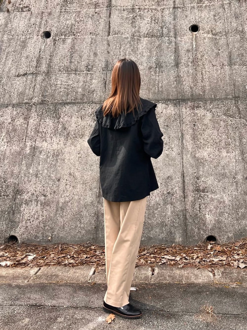 ブラック系のシャツ/ブラウス、ベージュ系のチノパンツを着用したレディースの冬コーディネートの2枚目の写真