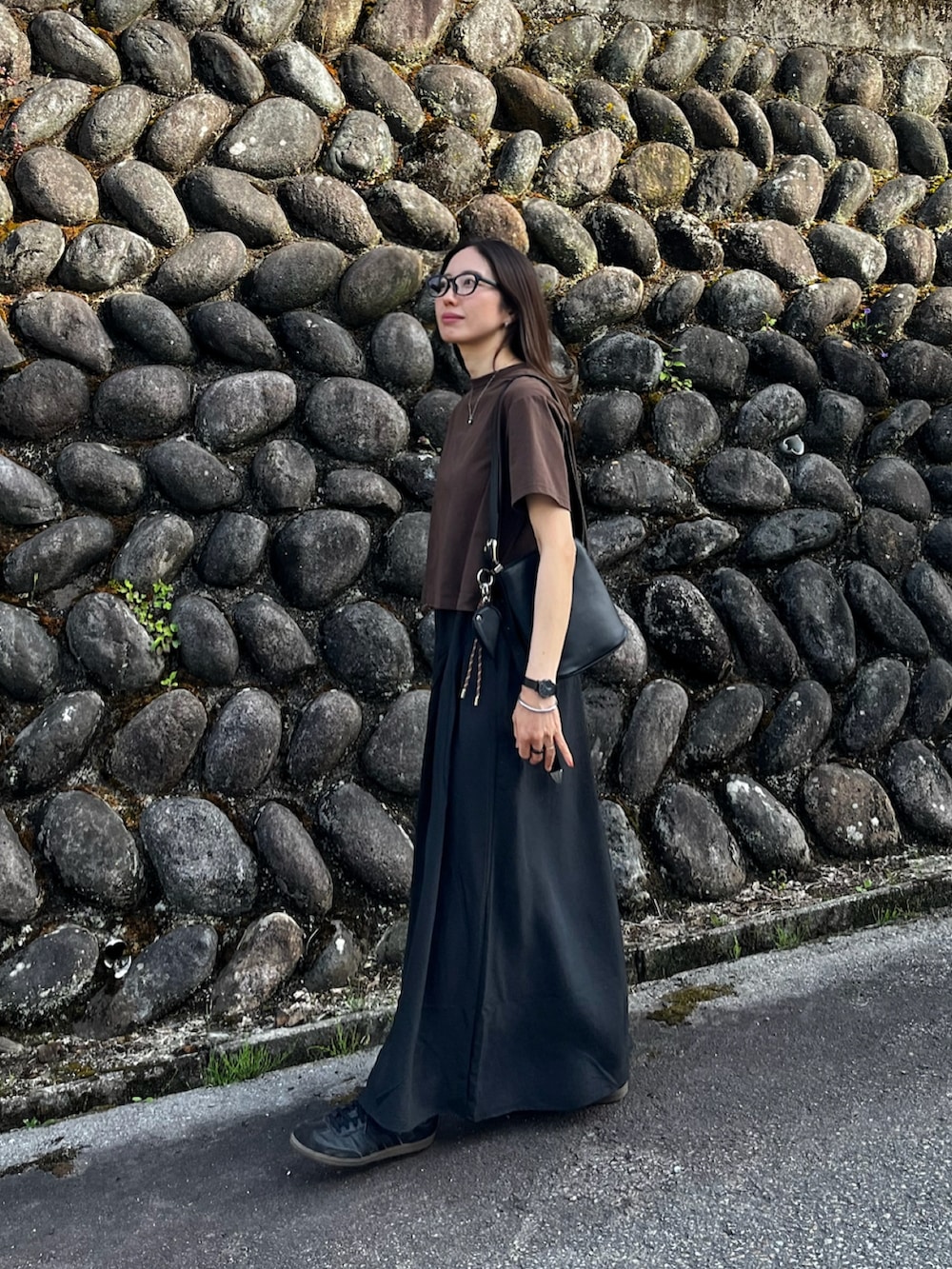 ブラック系のその他パンツ、ブラウン系のニット/セーター、ブラック系のバッグを着用したレディースの春コーディネートの2枚目の写真